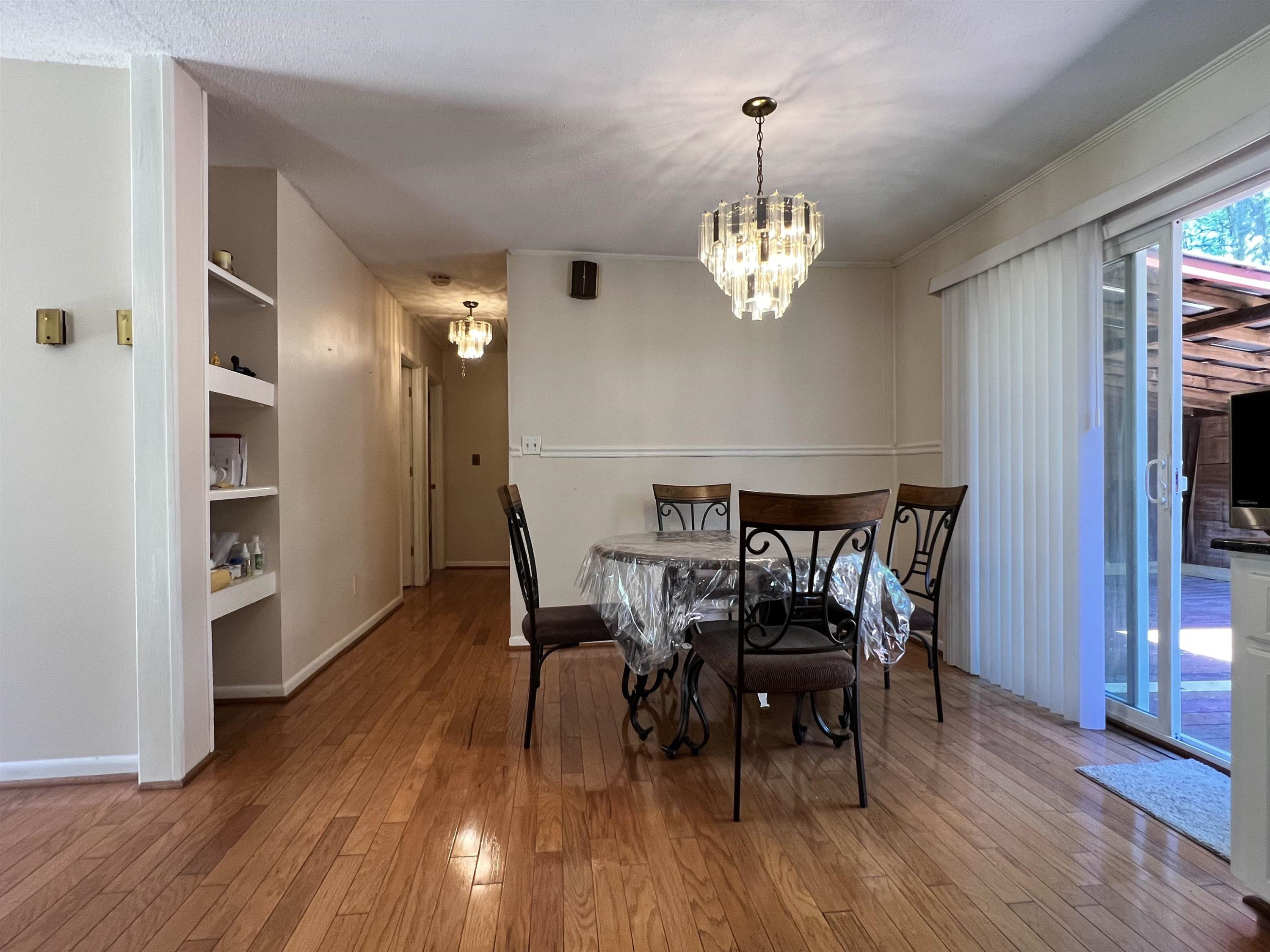 624 Woodland Road Raleigh, NC 27603 - Photo 14 of 29 a view of a dining room with furniture wooden floor and chandelier