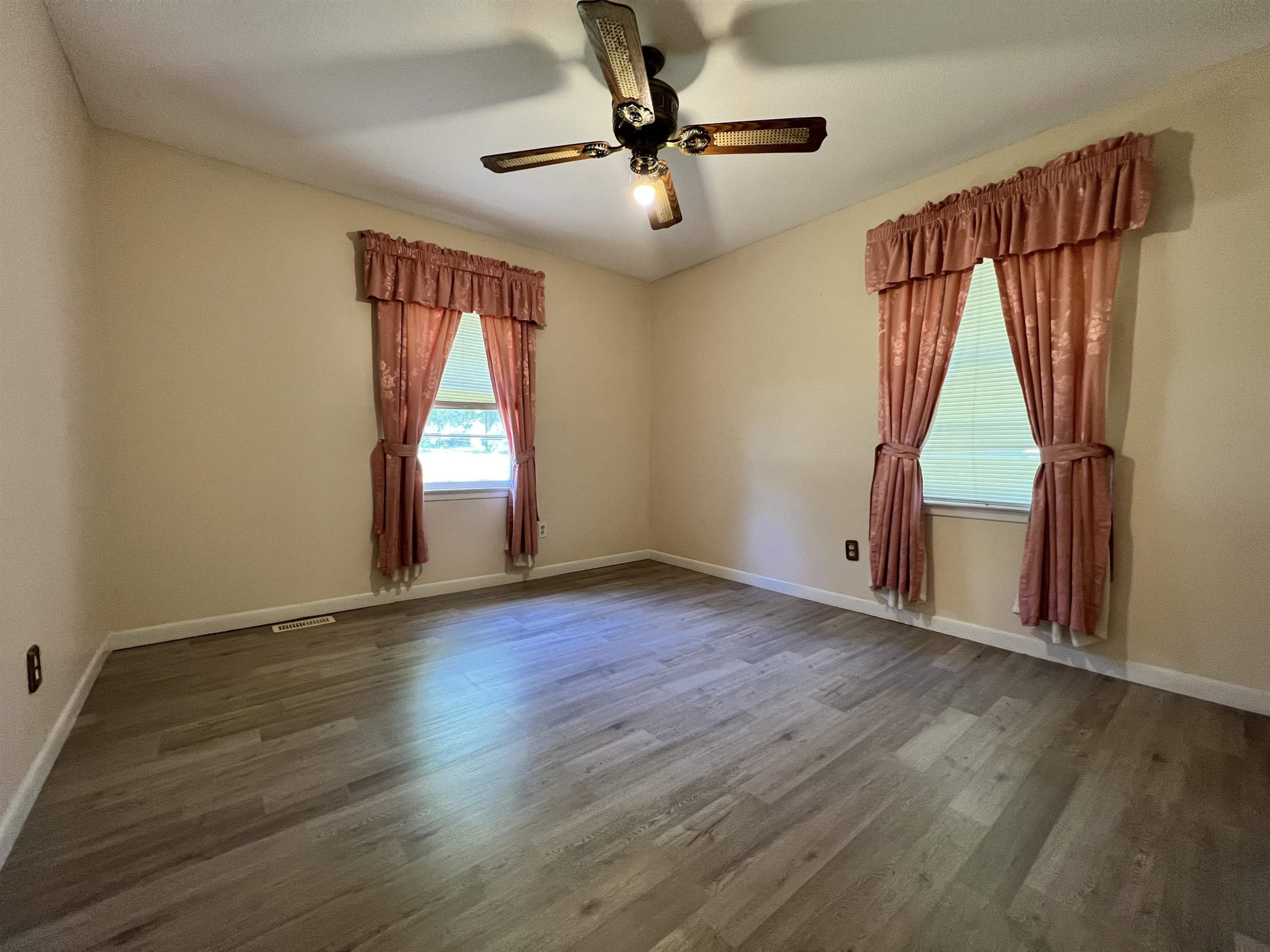 624 Woodland Road Raleigh, NC 27603 - Photo 18 of 29 an empty room with wooden floor fan and windows