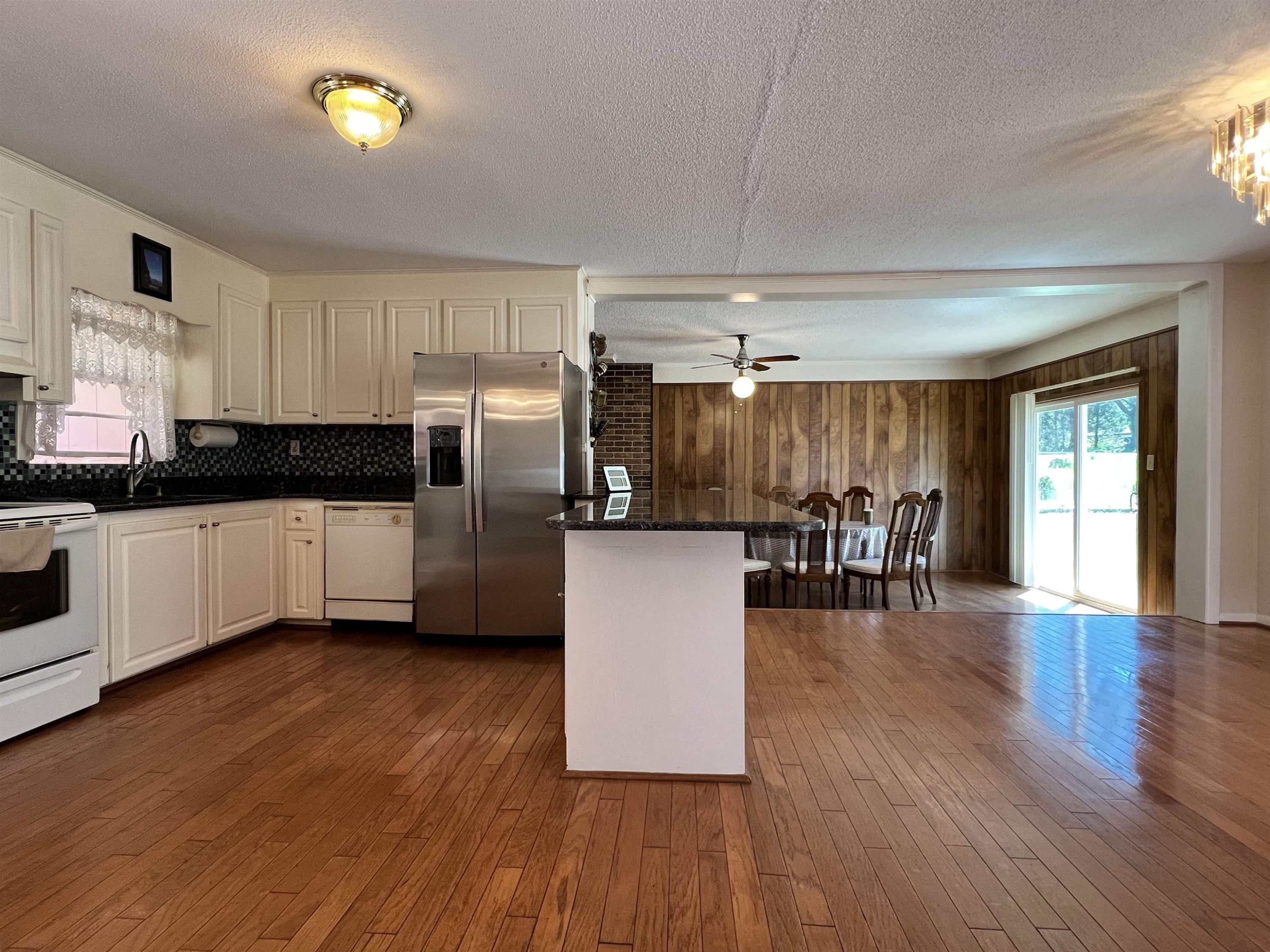 624 Woodland Road Raleigh, NC 27603 - Photo 8 of 29 a kitchen with stainless steel appliances wooden floors and wooden cabinets