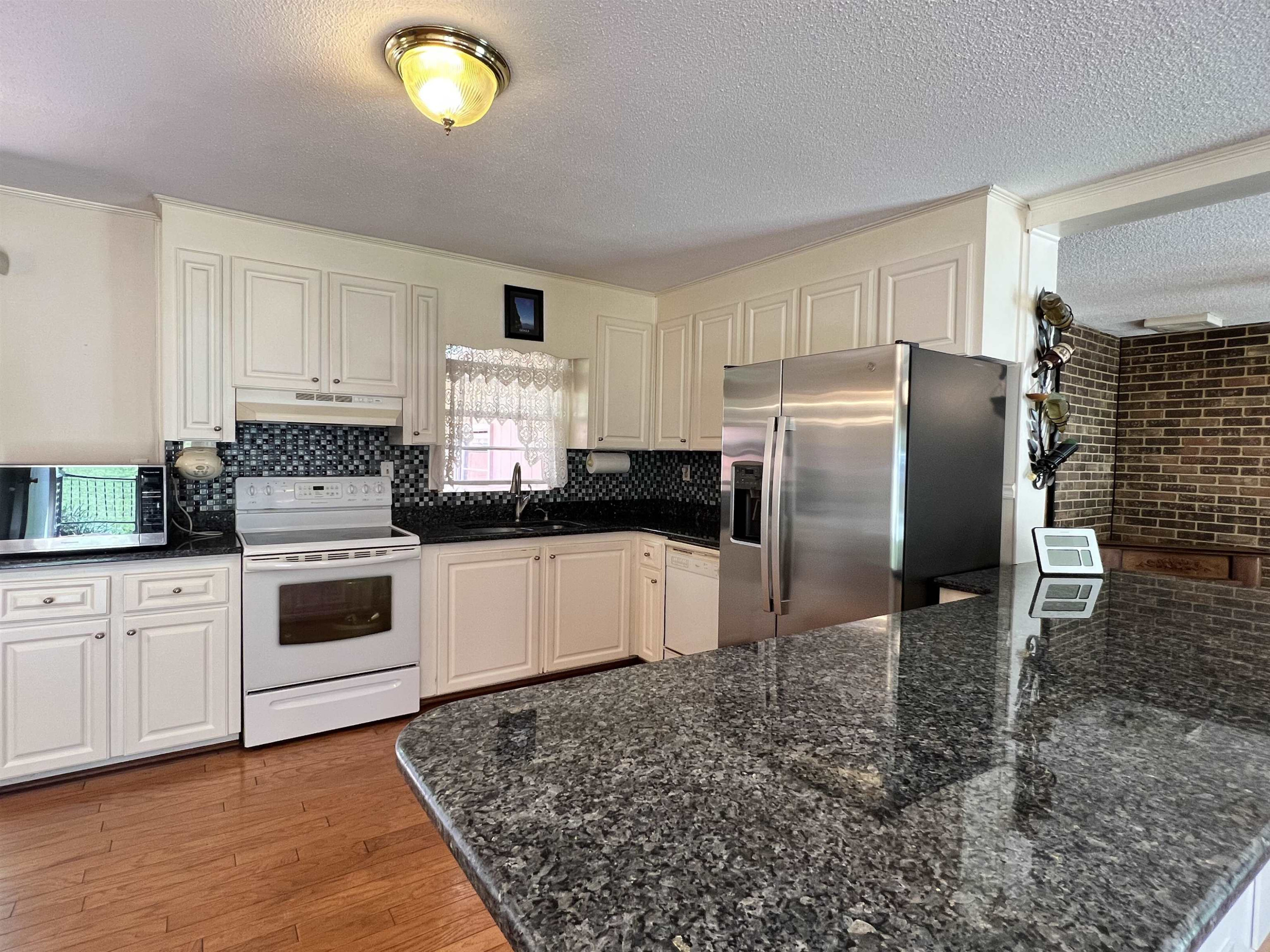 624 Woodland Road Raleigh, NC 27603 - Photo 9 of 29 a kitchen with granite countertop a refrigerator and a stove top oven