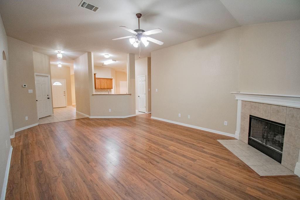 312 Pheasant Ridge Drive Round Rock, TX 78665 - Photo 6 of 34 Laminate wood flooring sweeps across this open concept living area, highlighting a cozy fireplace.