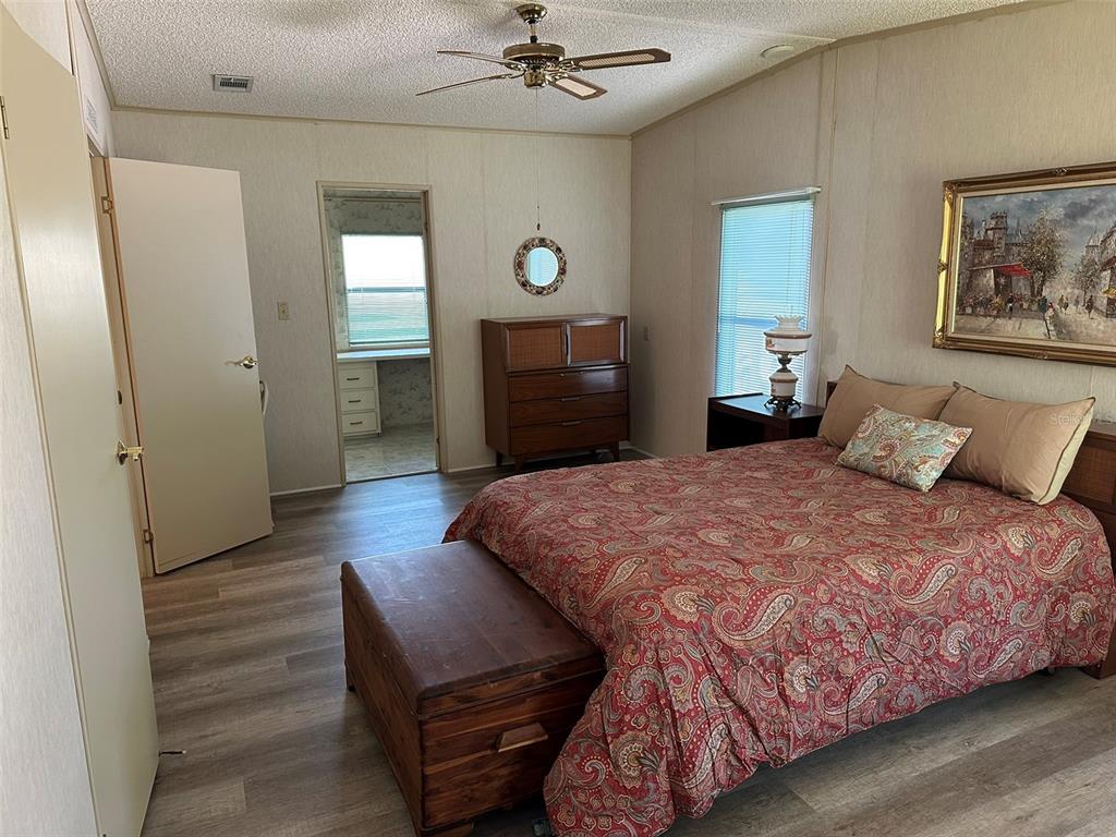76 Eagle Circle Ellenton, FL 34222 - Photo 17 of 22 a bedroom with a bed mirror on desk and a window