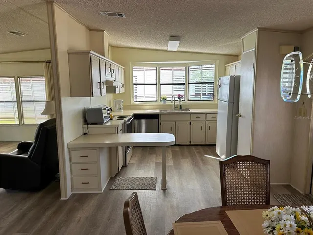 a kitchen with sink refrigerator and window