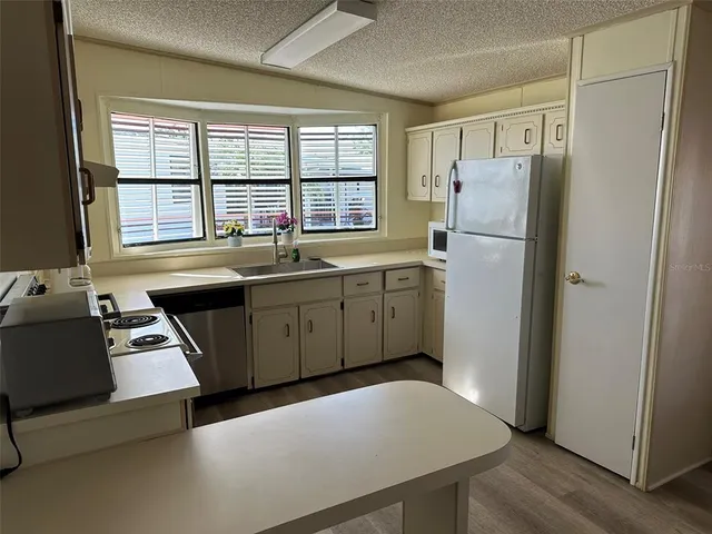 a kitchen with stainless steel appliances a refrigerator a sink a stove and a refrigerator