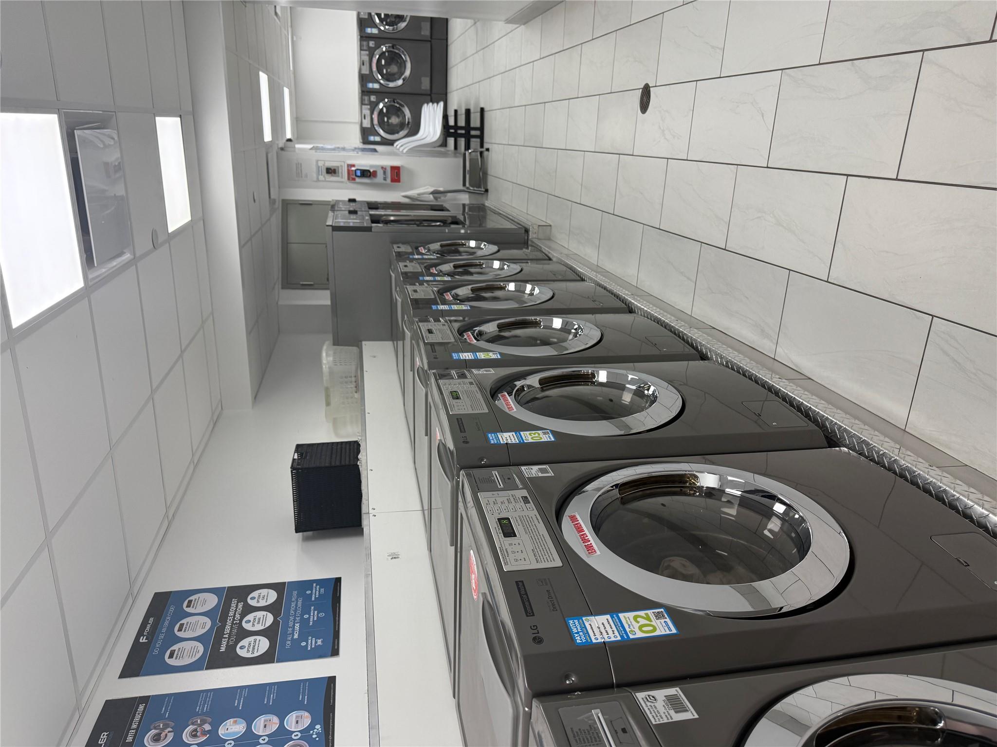 150 West 51st Street, Unit 1032 Manhattan, NY 10019 - Photo 19 of 19 a view of washer and dryer with kitchen in the background
