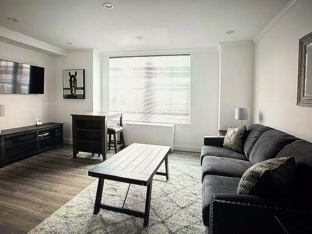 150 West 51st Street, Unit 1032 Manhattan, NY 10019 - Photo 3 of 19 a living room with furniture a flat screen tv and a window