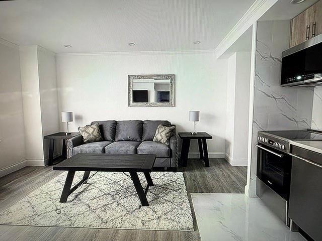 150 West 51st Street, Unit 1032 Manhattan, NY 10019 - Photo 4 of 19 a living room with furniture and a flat screen tv