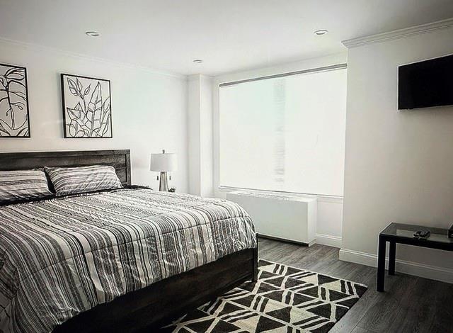 150 West 51st Street, Unit 1032 Manhattan, NY 10019 - Photo 6 of 19 a bedroom with a bed and a flat screen tv
