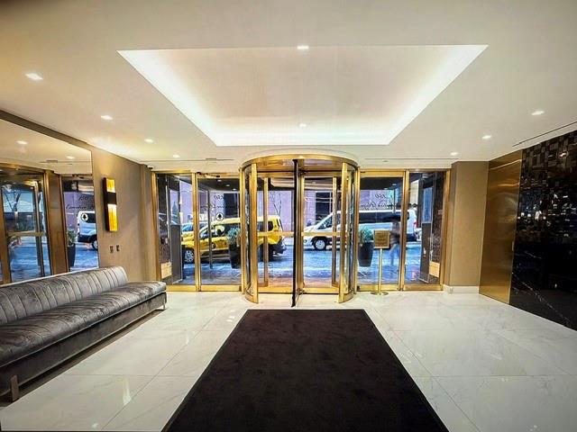 150 West 51st Street, Unit 1032 Manhattan, NY 10019 - Photo 9 of 19 a view of a living room with lots of furniture and a large window