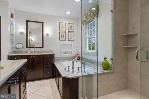 a bathroom with a granite countertop sink a mirror and a shower