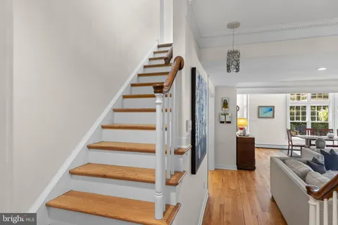 a view of a hallway with wooden floor and a living room