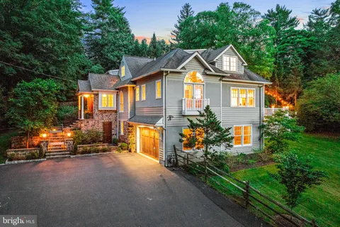 a front view of a house with a yard and potted plants