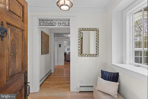 a hallway with front door wooden floor and windows