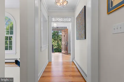 a view of a hallway with wooden floor and a window