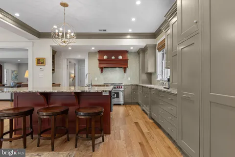 a large kitchen with stainless steel appliances granite countertop a sink and cabinets