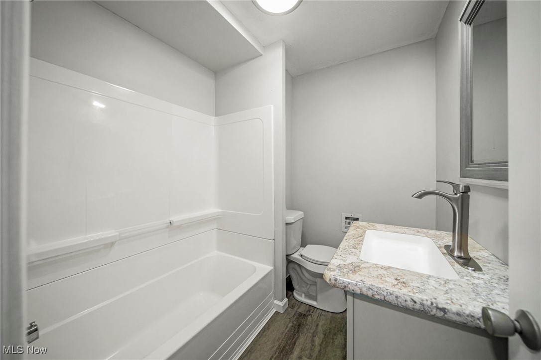 91 Paradise Road Painesville, OH 44077 - Photo 19 of 39 Full bathroom with dark wood-style floors, vanity, and shower / bathtub combination