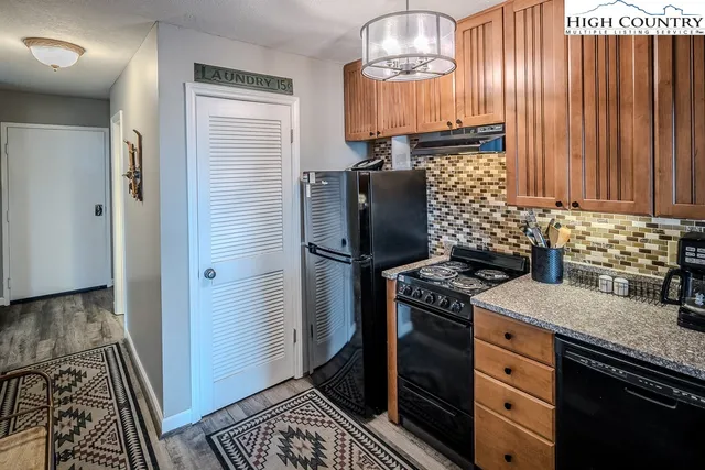 a kitchen with stainless steel appliances granite countertop a stove a sink dishwasher and cabinets with wooden floor