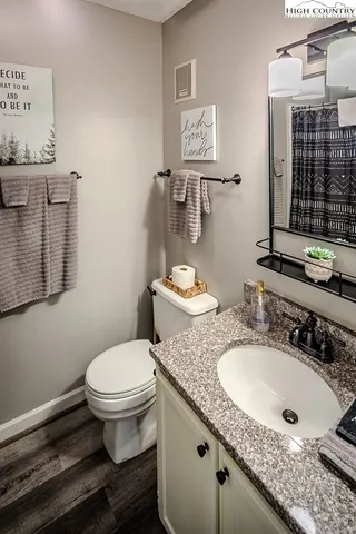 a bathroom with a granite countertop toilet sink and mirror