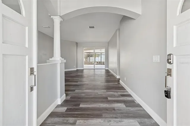 a view of empty room with window and wooden floor