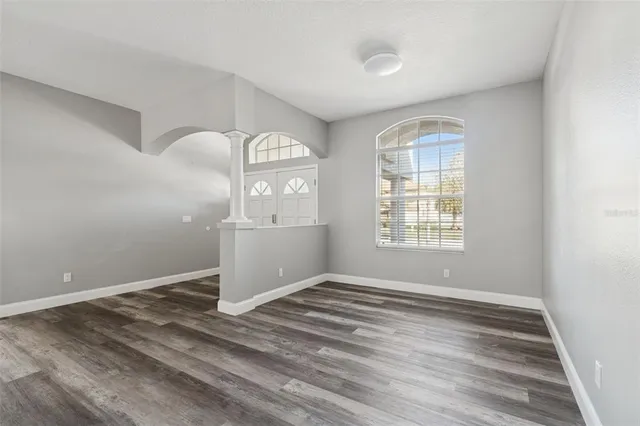 a view of a hallway with wooden floor and a bathroom