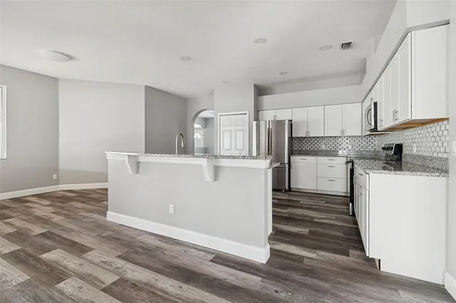 a bathroom with a granite countertop toilet a sink and a mirror