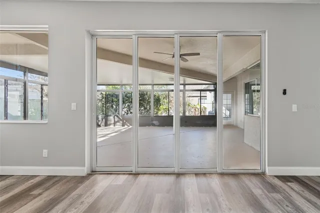 a view of an empty room with a floor to ceiling window and chandelier