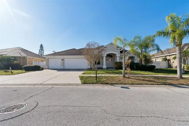 a view of a house with a yard and palm trees