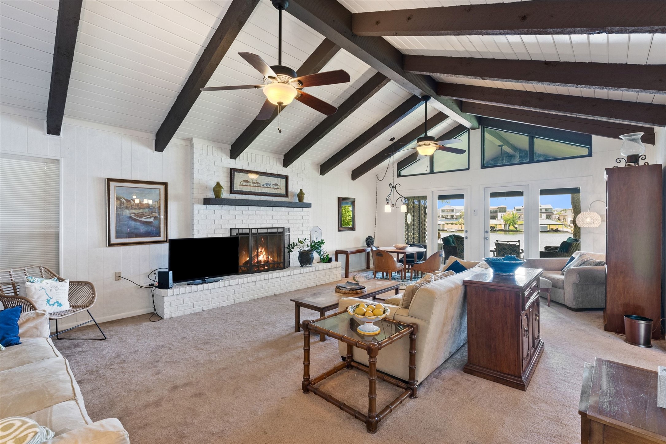 141 Perry Lane Kingsland, TX 78639 - Photo 14 of 40 A spacious living area with exposed beams and a fireplace provides a cozy atmosphere with direct access to waterfront views.