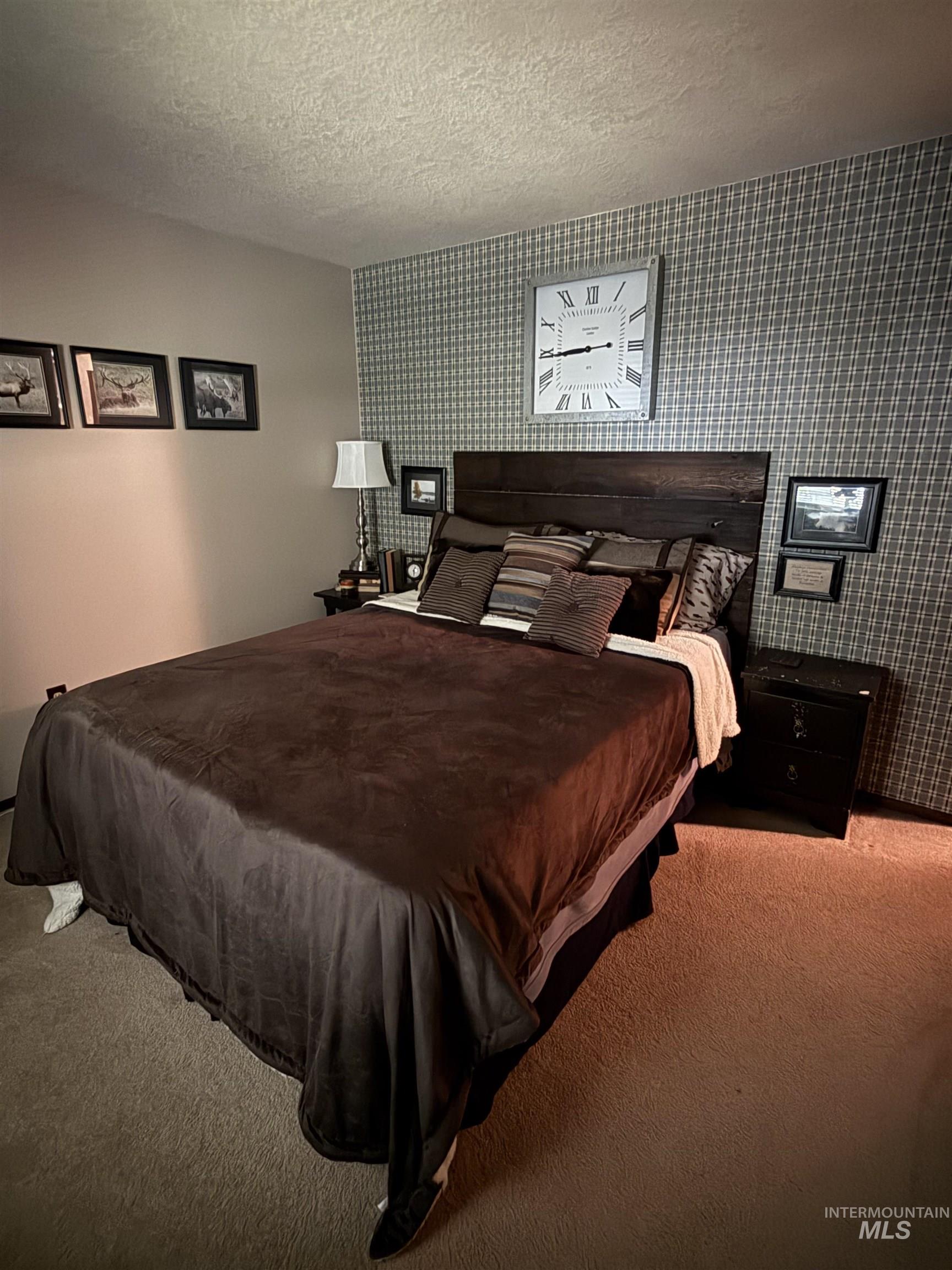 403 138th Street Orofino, ID 83544 - Photo 12 of 32 Bedroom featuring carpet floors, wallpapered walls, and a textured ceiling