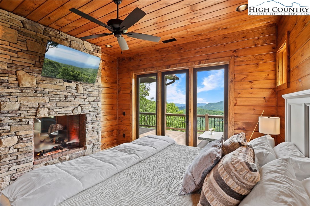 543 Broken Arrow Trail Boone, NC 28607 - Photo 13 of 46 a bed sitting in a bedroom next to a fireplace with a balcony fireplace