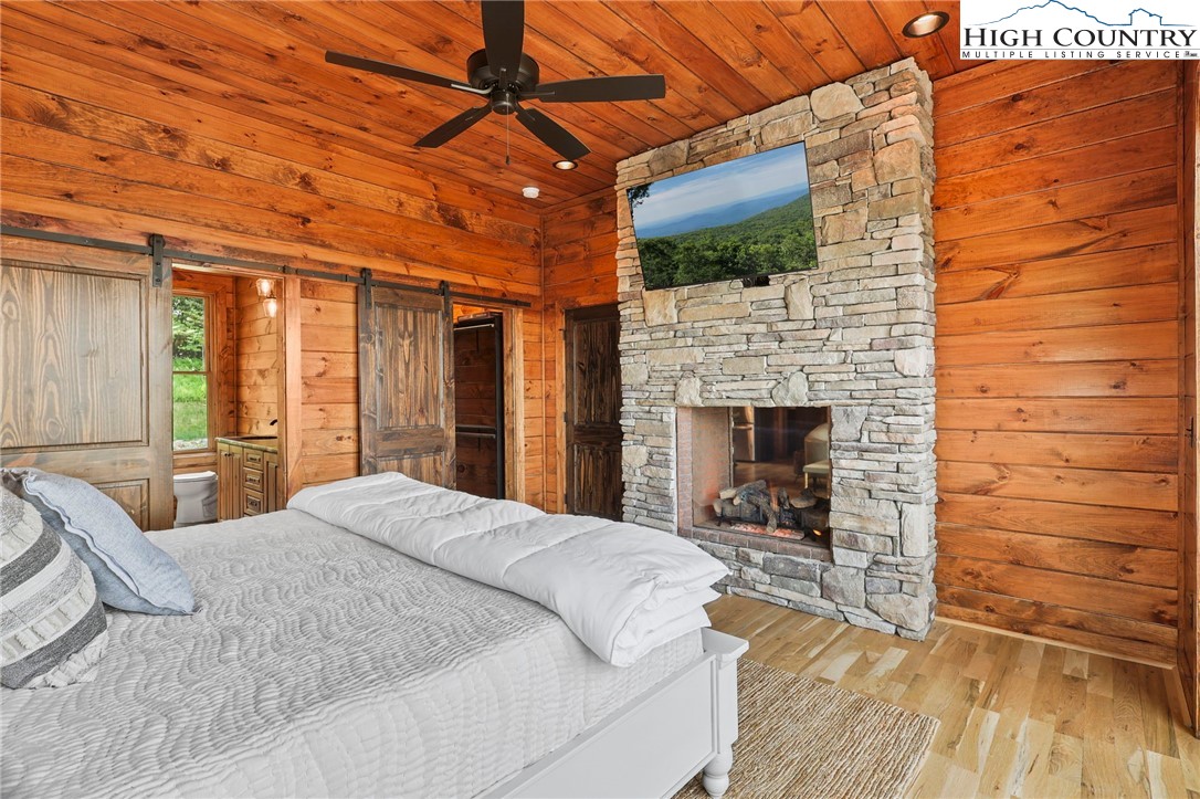 543 Broken Arrow Trail Boone, NC 28607 - Photo 16 of 46 a large bedroom with a bed and a fireplace