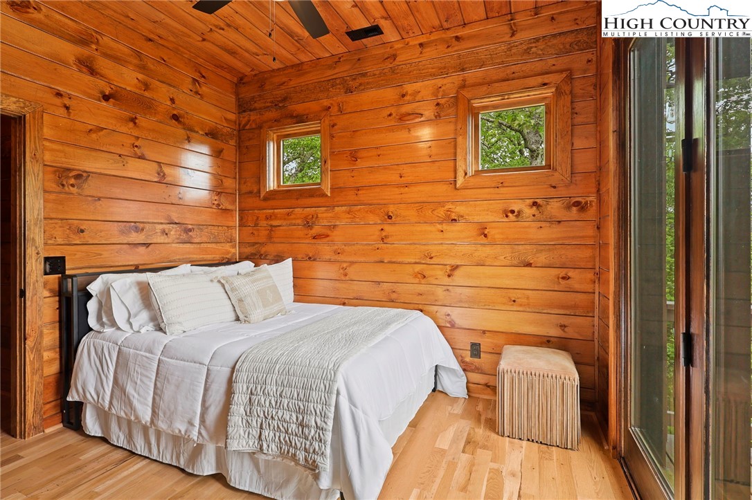 543 Broken Arrow Trail Boone, NC 28607 - Photo 19 of 46 a bed sitting in a bedroom next to a wooden door