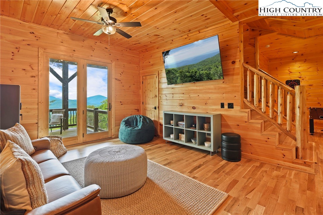543 Broken Arrow Trail Boone, NC 28607 - Photo 28 of 46 a living room with furniture a flat screen tv and floor to ceiling window