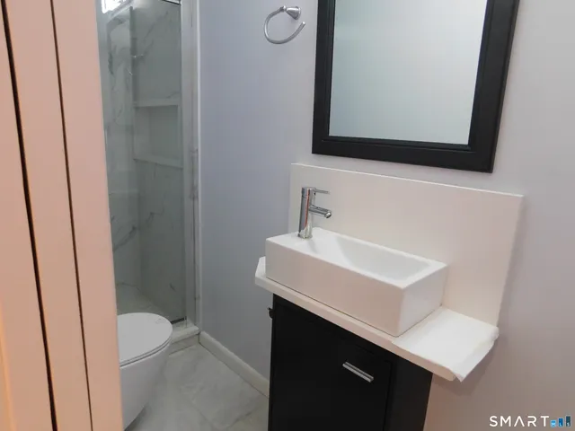 a bathroom with a sink toilet and mirror