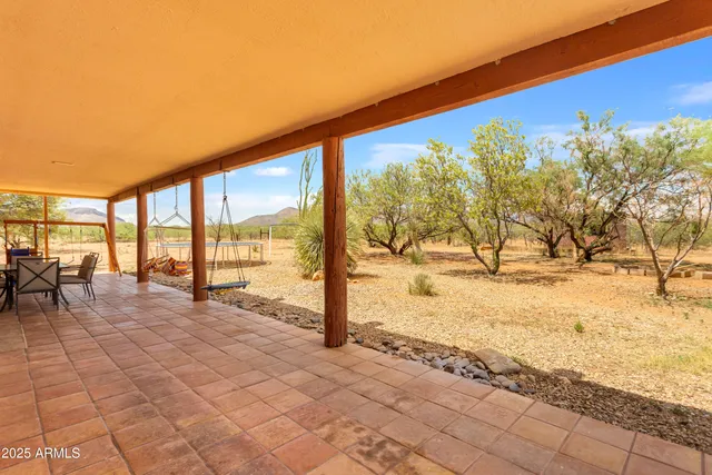 a view of swimming pool with lawn chairs under an umbrella