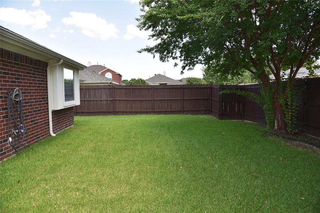 1526 Pebblestone Court Allen, TX 75002 - Photo 26 of 28 Expansive backyard featuring a lush green lawn, full privacy fencing, and a mature shade tree