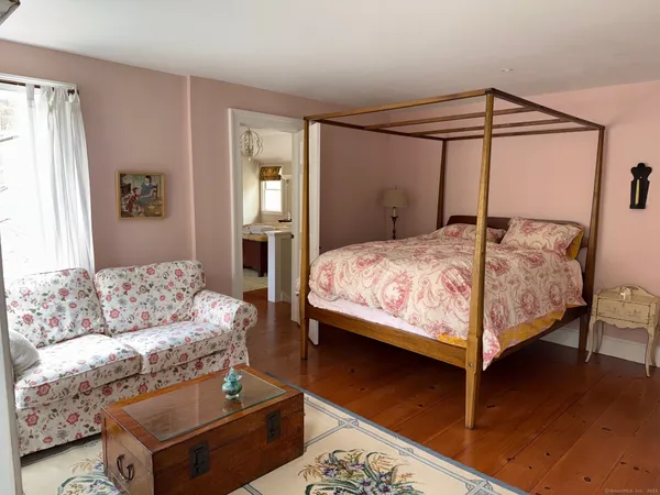 a bedroom with a bed couch and a window