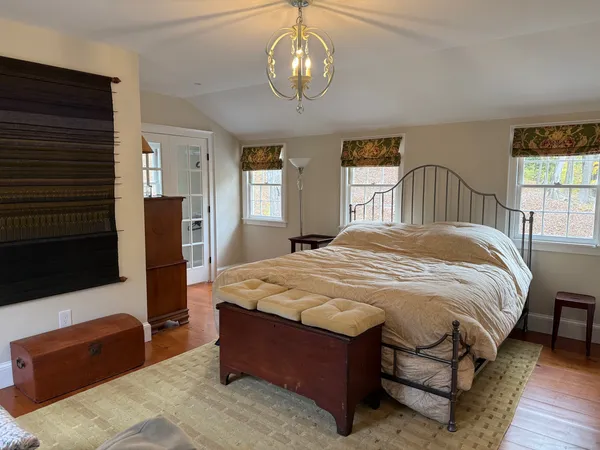 a spacious bedroom with a bed mirror and a window