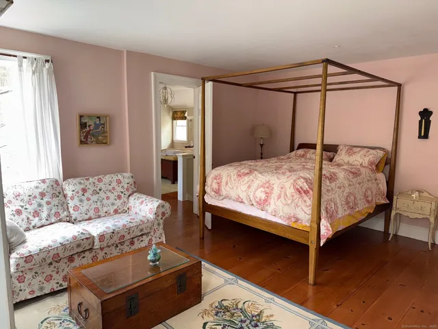a spacious bedroom with a bed mirror and a window