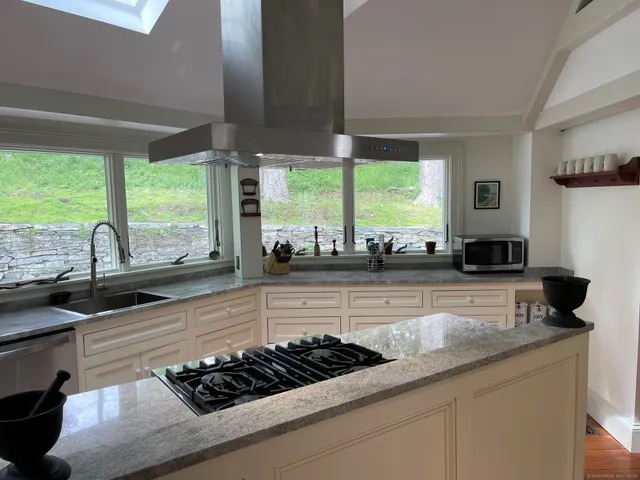 a kitchen with a stove and a wooden floor