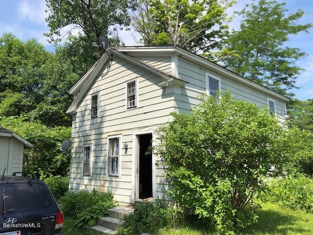 a view of house with a yard and potted plants
