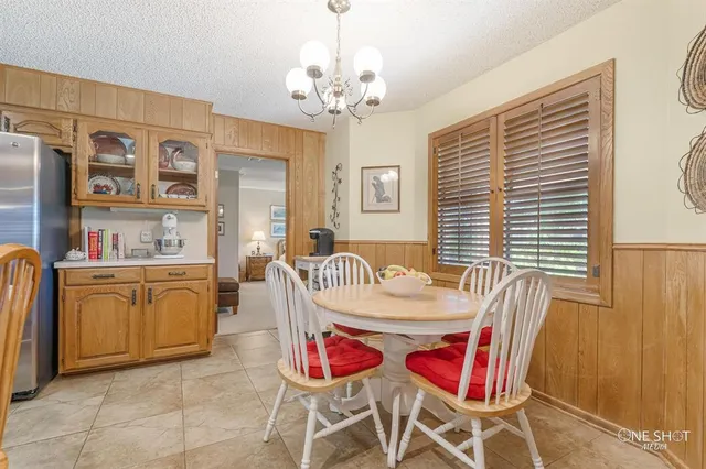 a kitchen with stainless steel appliances granite countertop a refrigerator a stove top oven and white cabinets