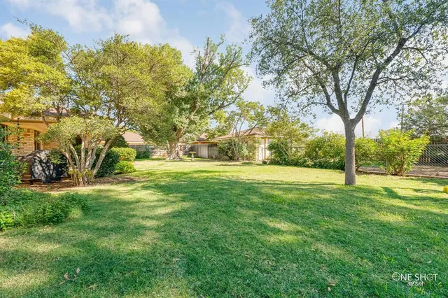 a front view of house with yard and trees around