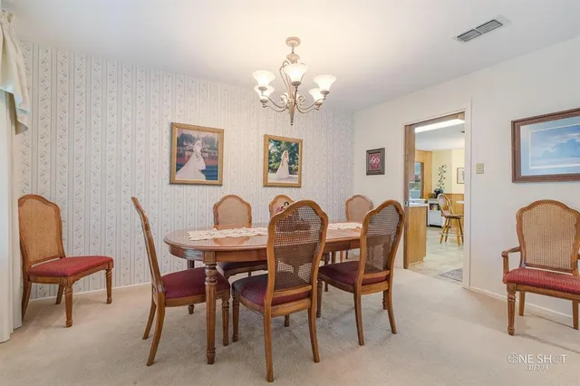 a living room with patio furniture and a chandelier