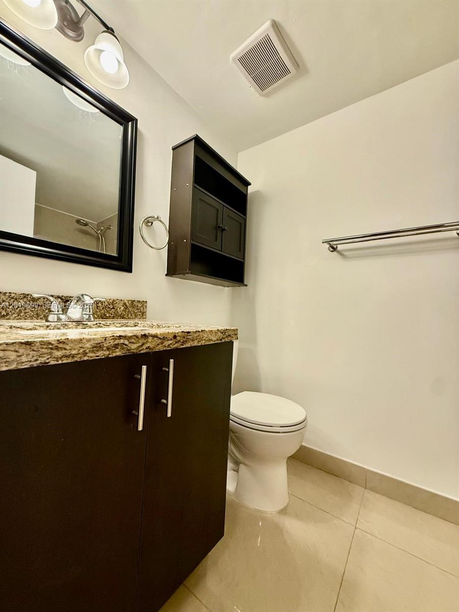 3470 Foxcroft Road, Unit 204 Miramar, FL 33025 - Photo 18 of 40 a bathroom with a granite countertop toilet sink and mirror