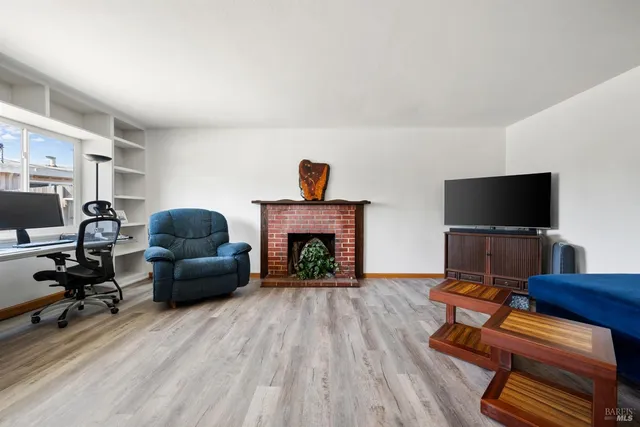 a living room with furniture a flat screen tv and a fireplace