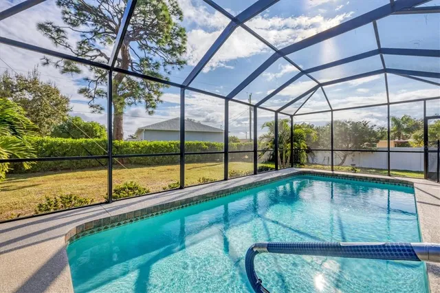 a view of a swimming pool with chairs and a table under an umbrella