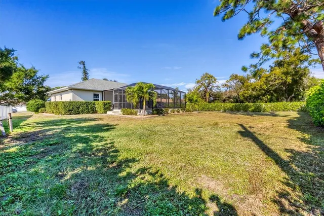 a view of swimming pool in front of residential houses with yard