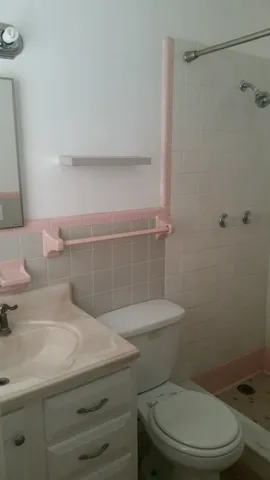 a bathroom with a granite countertop toilet and a sink