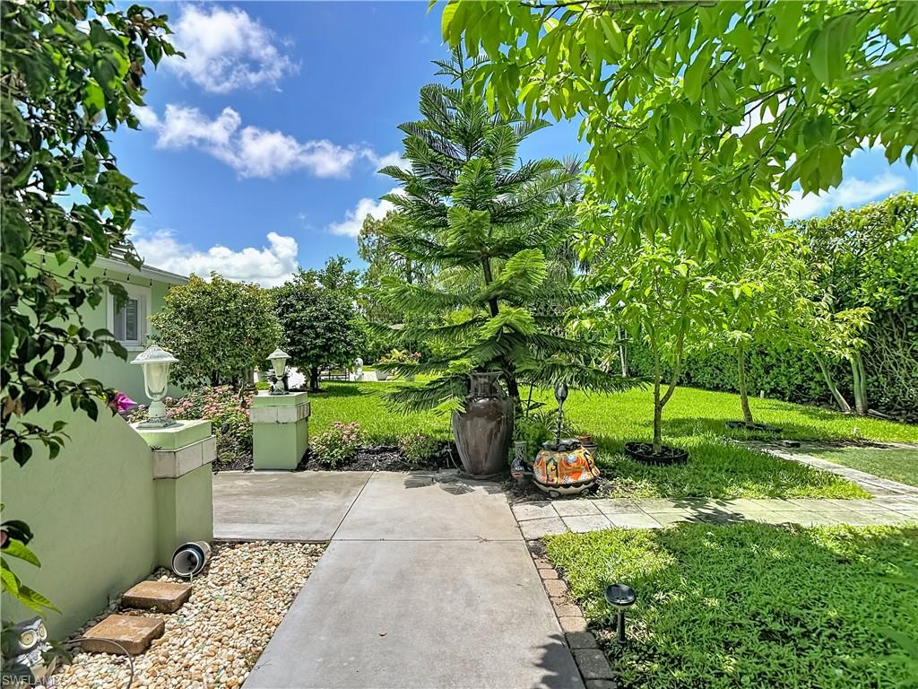 2280 Capri Court Naples, FL 34105 - Photo 38 of 49 a view of a backyard with potted plants and large trees
